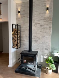 a wood burning stove in a living room next to a potted houseplant