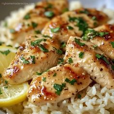 chicken and rice with lemon wedges on the side