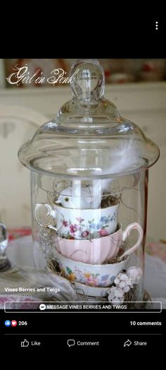 a glass jar filled with tea cups and saucers