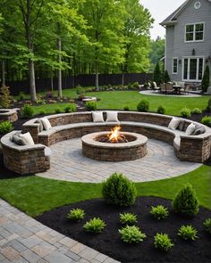 an outdoor fire pit surrounded by landscaping