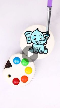 a cupcake with an elephant painted on it and a paintbrush next to it