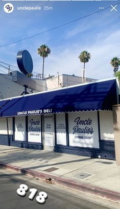 the outside of a restaurant with blue awnings and palm trees in the background