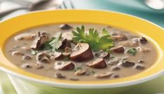 a yellow bowl filled with mushroom soup and garnished with parsley