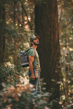 a man with a backpack standing in the woods