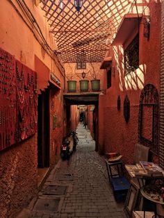 an alley way with tables and chairs on either side