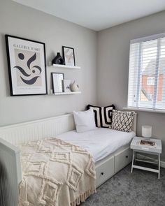 a bedroom with a bed, nightstands and pictures on the wall