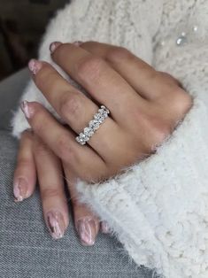 a woman's hand wearing a diamond ring