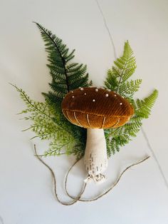 a mushroom and fern on a white surface