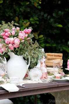 a table topped with pink flowers and plates