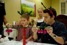 a man and two children wearing reindeer antlers on their heads at a christmas party