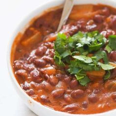 a white bowl filled with beans and cilantro