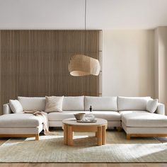 a living room filled with furniture and a large wooden screen behind the sectional couches