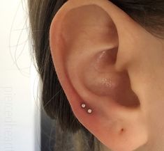 a woman's ear with two small white dots on it