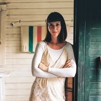 a woman standing in front of a door with her arms crossed