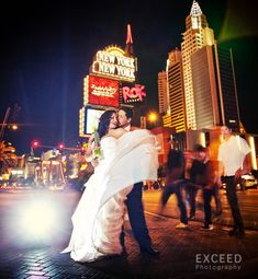 a bride and groom pose in front of the new york theatre