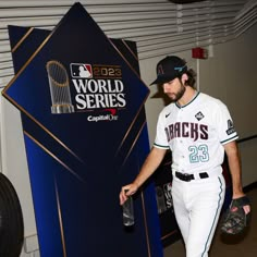 a baseball player walking into the dugout with his glove in hand while wearing a catchers mitt