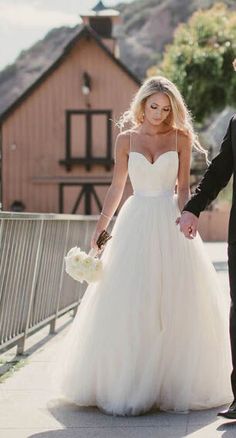 a man and woman holding hands walking down a street with the caption simple sweetheart spaghetti straps cheap custom long wedding dress bridal