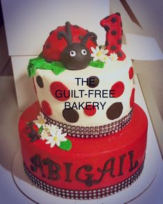 two tiered cake decorated with ladybugs and daisies for the guilt - free bakery