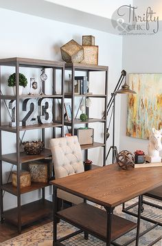 a table and chairs in a room with bookshelves on the wall behind them