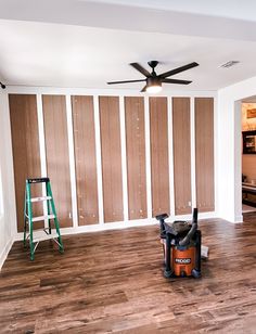 a room with hard wood flooring and walls painted in brown, white and black