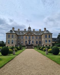 a large building with lots of trees and bushes around it