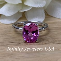 "The ring pictured is a lab created pink sapphire #6448 -Approximate total carat weight: approx. 3.00ctw diamond equivalent -Center Stone Size: 10x8mm - approx. 3.00ct diamond equivalent -Center Stone Shape: oval -Gem Type: lab created sapphire -Stone Clarity: VS2 -Stone Color: Medium Pink -Moh's Scale: 9 hardness -Metal Type and Purity: 14k white gold -Setting: 4 prong open U head -Stock Ring Size: 6 -Country of Manufacturing: USA (Michigan) For customization please contact us. If you have any Gia Certified Pink Ruby Ring, Gia Certified Oval Pink Ruby Ring, Classic Pink Ruby Ring With Center Stone, Gia Certified Classic Pink Sapphire Jewelry, Classic Gia Certified Pink Sapphire Jewelry, Classic Pink Ruby Ring With Accent Stones, Oval Ruby Ring With Brilliant Cut Pink Sapphire, Pink 14k White Gold Jewelry With Center Stone, Pink Oval Gemstone Birthstone Ring