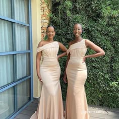 two women standing next to each other in dresses