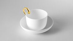 a white cup and saucer with a gold ring on the rim, sitting on a gray surface