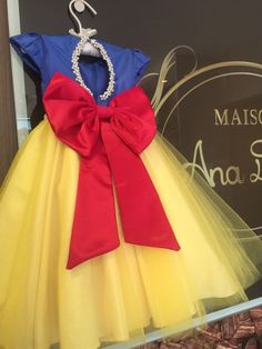 a dress made to look like snow white is on display in front of a sign