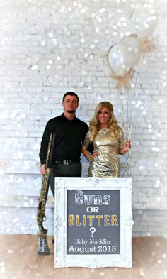 a man and woman standing next to each other in front of a white brick wall