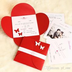 two red heart shaped envelopes sitting next to each other