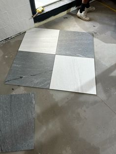 a person standing on the floor next to some tiles