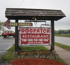 a sign advertising dogpatch restaurant and fine food for sale in front of a parking lot