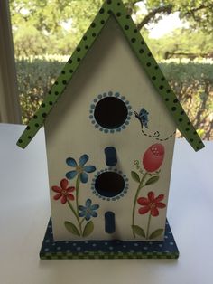 a bird house with flowers painted on it