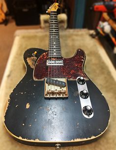 an old guitar sitting on top of a table