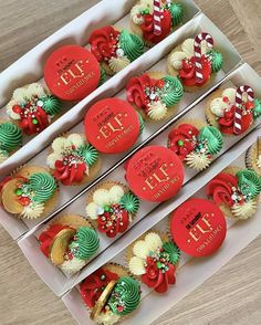 two boxes filled with cupcakes decorated like christmas wreaths and candy canes