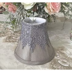 a vase filled with flowers sitting on top of a table next to a candle holder