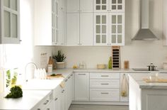 a kitchen with white cabinets and counter tops