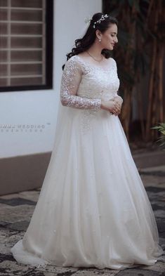 a woman in a wedding dress standing outside