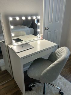 a white desk with a mirror and lights on it in front of a bed room door