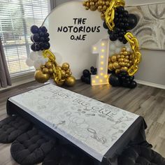 the balloon arch is decorated with black, gold and white balloons that spell out the word'the notaroous one '