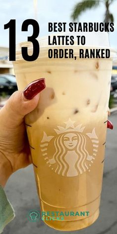 a woman holding up a starbucks drink with the words 13 best starbucks's lattes to order, ranked