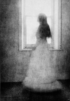 a woman standing in front of a window