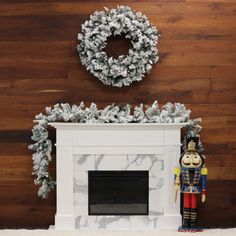 a fireplace with a wreath on top and a nutcracker figurine next to it