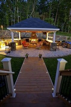 a gazebo with seating and lights in the evening