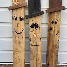 three wooden boards with faces painted on them