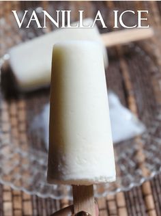 a hand holding an ice cream on a wooden skewer with the words vanilla ice above it