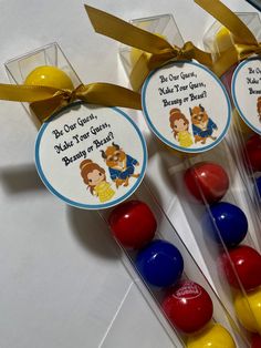 three candy lollipops with labels on them sitting next to some candies