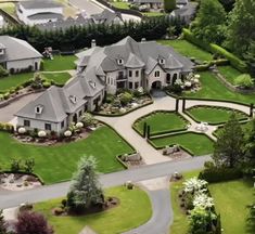 an aerial view of a large home surrounded by lush green grass and trees in the foreground