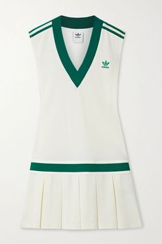 a white tennis dress with green trims on the front and bottom, featuring an adidas logo